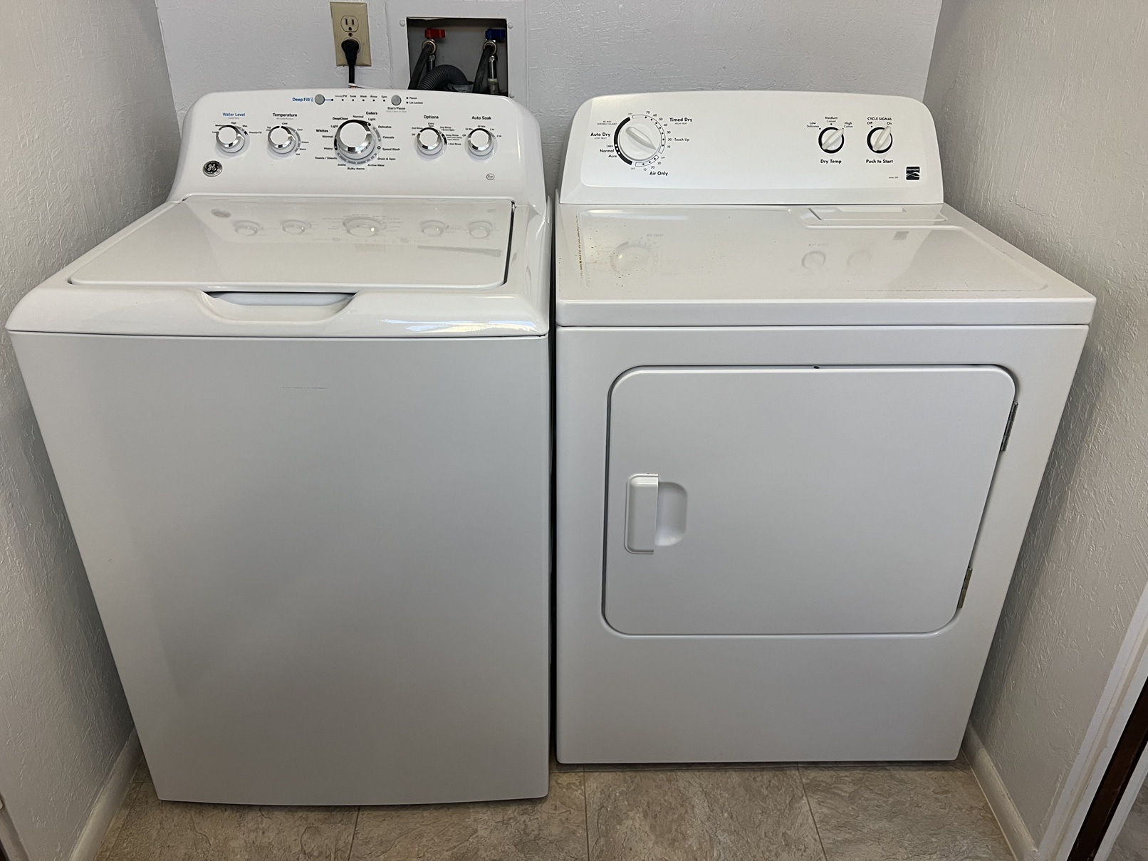 Two white front loading washing machines in a laundry room.